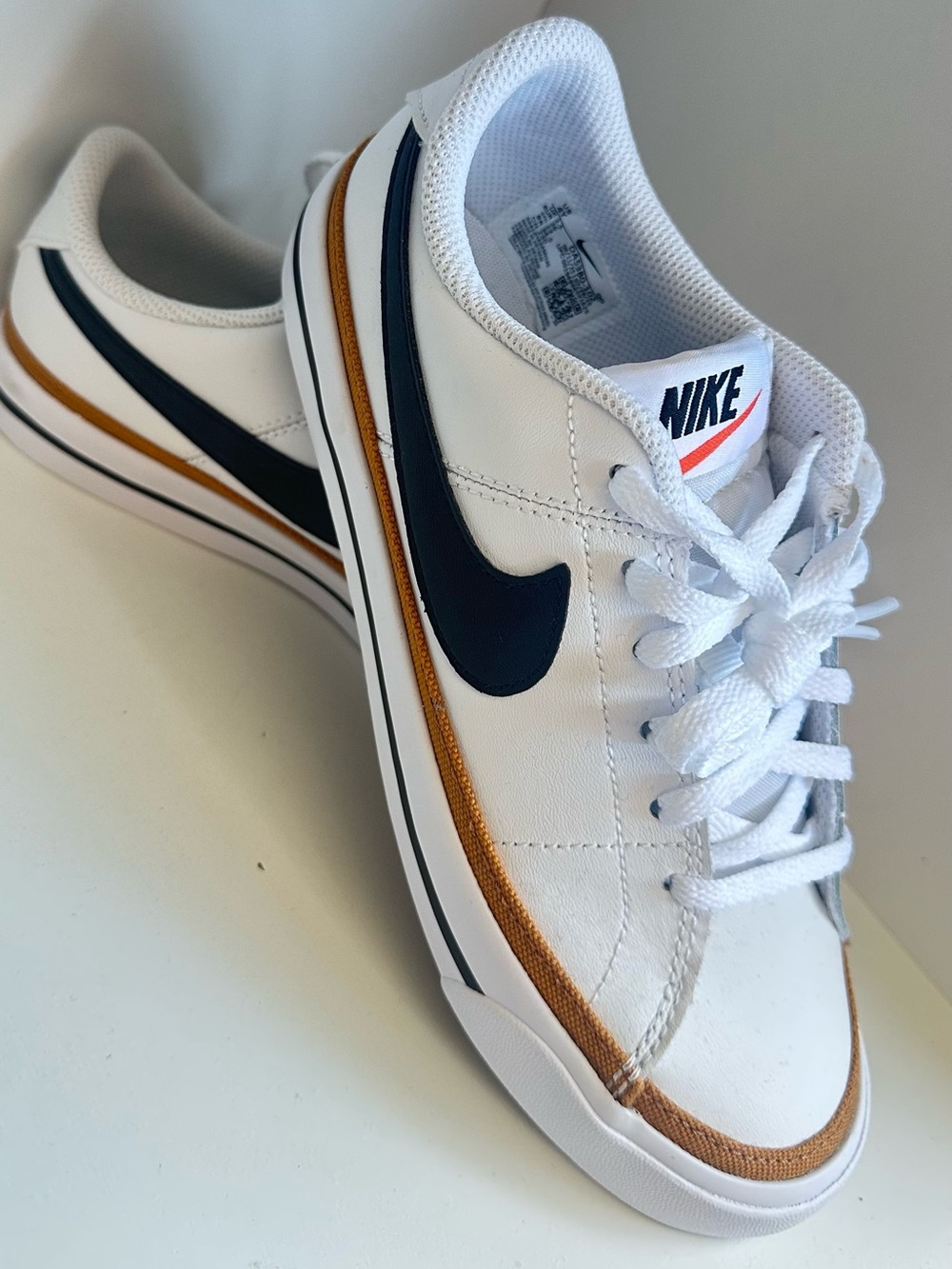 Nike White Leather Sneakers with Navy Swoosh and Gold Accent